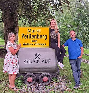 Das Team der vhs Peißenberg mit einem Ortsschild.