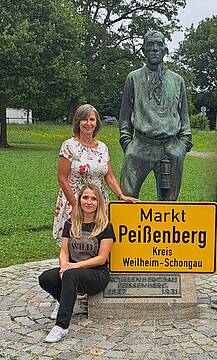 Das Team der vhs Peißenberg mit einem Ortsschild.